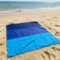 Detailed view of waterproof blue beach mat spread on sandy shore near sea waves. - 140*200cm / Dark, Medium and Light Blue Patchwork