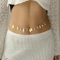 Detail view of a bohemian style shell and starfish waist chain on a model's waist - Cream Woven Marine Charm Style (BJ26Y0080-1)