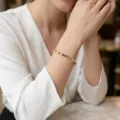 Close-up of elegant gold floral bracelet with purple gems on model's wrist - Gold Purple Pink Zirconia
