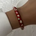 Handcrafted ethnic style red enamel cloisonné floral pattern bangle shown worn on a wrist - 6CM Diameter / Red Base Colored Floral Style (BR26Y0273-3)