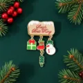 Close-up of Christmas enamel brooch with snowman, gift, and stocking charms - Snowman with Gift Box