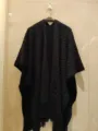 Gedetailleerd uitzicht op een zwarte gebreide poncho sjaal, met opengewerkte patronen voor dames. - 160cm / Zwart