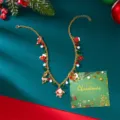 Detaillierte goldene Weihnachtshalskette mit Weihnachtsmann- und Rentieranhängern auf einer Karte - Weihnachtsmann Rentier Stil (NC25Y0762-1)