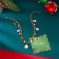 Festliche goldene Weihnachtskette mit Weihnachtsmann-Anhängern auf grünem Hintergrund - Weihnachtsmann Schneemann Stil (NC25Y0762-2)
