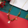 Vista de detalle de un collar de Navidad dorado con dijes de muñeco de nieve y abeto. - #3 Collar