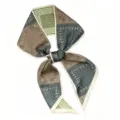 Gedetailleerde close-up van een stijlvolle lange paisley sjaal met kaki patchwork design. - Groene schaakbord paisley
