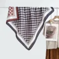Gedetailleerd overzicht van de dubbelzijdige geruite sjaal met contrasterende kleuren en zachte textuur. - 41