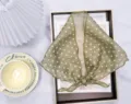 Gedetailleerd overzicht van de groene chiffon driehoekige sjaal met stippen en strik - Donker Koffie