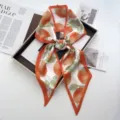 Detailed view of stylish orange citrus print silk ribbon scarf with vibrant color border. - Style 7