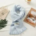 Detailed view of light blue plaid winter warm scarf with cute bear label and fringes. - Fresh Style Blue