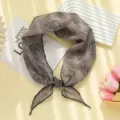 Gros plan sur le foulard triangulaire rétro cachemire avec une texture de tissu fine et élégante. - Foulard Triangulaire Paisley / Gris