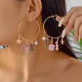Festive Christmas hoop earrings with Santa, reindeer, and candy cane charms on model - Santa Claus Hoop Earrings