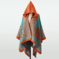 Detailansicht eines Strickponchos mit Kapuze und orange-türkisen geometrischen Mustern. - Oberteile / 135x150cm / Orange