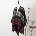 Zachte zwart-oranje gebreide ponchosjaal met geometrisch patroon op een mannequin - Gespleten sjaals met geometrisch doolhofpatroon - Zwart & oranje