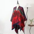 Rood en marineblauw etnisch jacquard gebreide sjaal poncho op een etalagepop in de kamer - Saffraanrood sjaal met split en gouden lotus