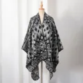 Detail of a knit men's shawl poncho featuring a black and grey geometric diamond pattern. - Black and Gray