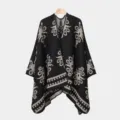 Detailansicht eines Herren-Ponchos mit Vintage-Strickmuster und warmer Textur - Schwarz Beige