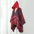 Detailed side view of a women's hooded knitted poncho with vintage geometric pattern - One Size / Cloak Colorful Geometric Red & Green