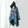 Detailansicht eines gestrickten Ponchos mit Kapuze und Paisley-Mustern in Türkis. - Cape-Stil / Marineblau