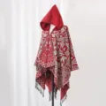 Roter Herren-Strickponcho mit Kapuze, aufwendigen Jacquard-Mustern und schwarzen Fransen - Rot