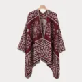 Detailansicht eines weinroten Herren-Ponchos mit geometrischen Jacquard-Mustern. - Burgunderrot