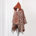 Detailansicht des ethnischen Musters und der Quasten an einem Herren-Strickponcho mit Kapuze - Karamellbraun