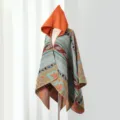 Detailansicht eines bunten gestrickten Kapuzenponchos mit elegantem Paisleymuster - Cape-Stil / Orange