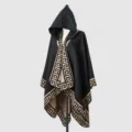 Detailansicht eines schwarzen Strickponchos mit Kapuze und elegantem beigen Mäander-Muster-Rand - Schwarz