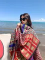 Detailed view of an ethnic style thick warm shawl with vintage patterns worn by sea - Size 9