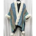 Detailansicht eines ethnischen blauen Strickponchos mit Kunstpelzkragen und weichen Pompons. - Morgenmantel / Hellblau