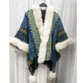 Detailansicht eines ethnischen Strickponchos mit weißem Kunstfellkragen und Pompons - Morgenmantel / Marineblau