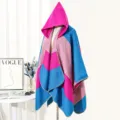 Detailed macro view of the colorful striped knitted hooded poncho shown on a mannequin - Rose Red