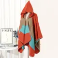 Detailed view of colorblock hooded knit poncho with orange, teal and brown patterns - Orange