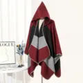 Detailed view of a stylish color-block hooded knit poncho displayed on a mannequin - Burgundy
