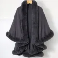 Detail shot of a dark grey knitted shawl featuring plush faux fur trim and dual layers. - Tops / Gray