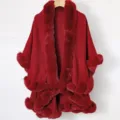 Close-up detail of a luxury red knitted shawl with elegant faux fur trim and pom-pom hemline - Tops / Burgundy