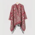 Detailed view of red knit poncho featuring vintage floral patterns and black fringe tassels - Red Split Scarf
