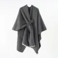 Detailed view of the gray knit poncho featuring a unique diagonal strap and fringe edges - 130*160cm / Black