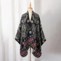 Close-up of knit poncho featuring intricate black and grey paisley floral patterns - Small Paisley / Slit Scarf / Black