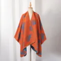 Detailansicht eines herbstlichen Strickponchos mit blauem Ginkgo-Muster auf orangefarbenem Grund - 130*150cm / Orange