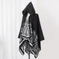 Detailansicht eines schwarzen Kapuzenponchos mit böhmischem Blumenmuster auf einer Puppe. - Stil 1 / Schwarz