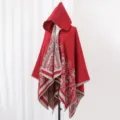 Detail eines roten Strickponchos mit Kapuze, Ethno-Paisley-Muster und Fransenrändern - Stil 1 / Rot