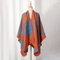 Detailansicht eines orange-blauen Strickschals mit floralem Muster und Schlitz - Orange
