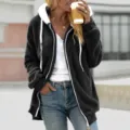 Detailed shot of women's warm fleece zip-up hoodie in black with cozy white hood lining. - S / Black