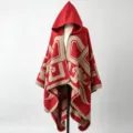 Detailed view of a thick red and beige hooded cloak with geometric patterns on a mannequin. - One Size / Red