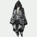 Damen Strick-Poncho mit Kapuze und eleganten schwarz-weißen Schnörkelmustern für Herbst. - Morgenmantel / Schwarz