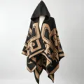 Detailed view of women's hooded poncho with ethnic geometric pattern in black and camel - One Size / Black and Camel