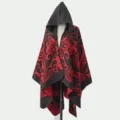 Detaillierte Ansicht des Strickponchos mit Kapuze und kräftigen rot-schwarzen Stammesmustern - Morgenmantel / Schwarz Rot