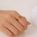 Nahaufnahme eines vergoldeten Edelstahl-Lagenrings mit T-Steg-Akzenten an einer Frauenhand - 金色款式三(RI25Y0030)