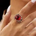 Detailed close-up of a gothic silver devil's claw ring with a striking red evil eye - Open Adjustable / Red